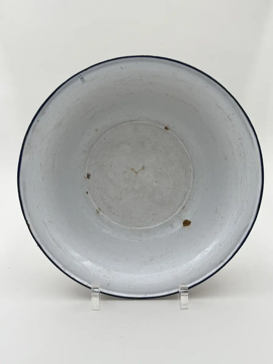 Skål av vitemaljerad plåt, utsvängd mynning, blå kant. Undersidan med frimamärke K.E.R. [Kockums Emaljerverk Ronneby] SWEDEN 32 cm. 