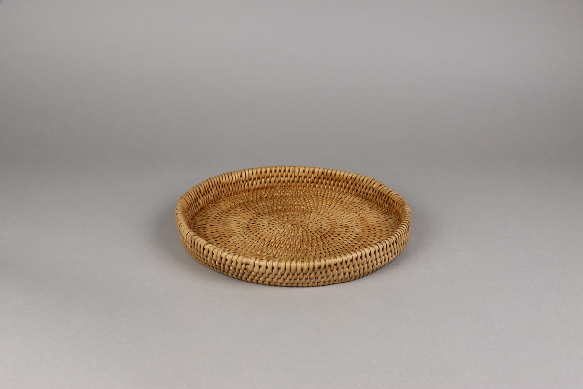 Korg bunden av kluvna rottågor över vidjor med löst lock. Rund bukig form med platt botten och platt lock.