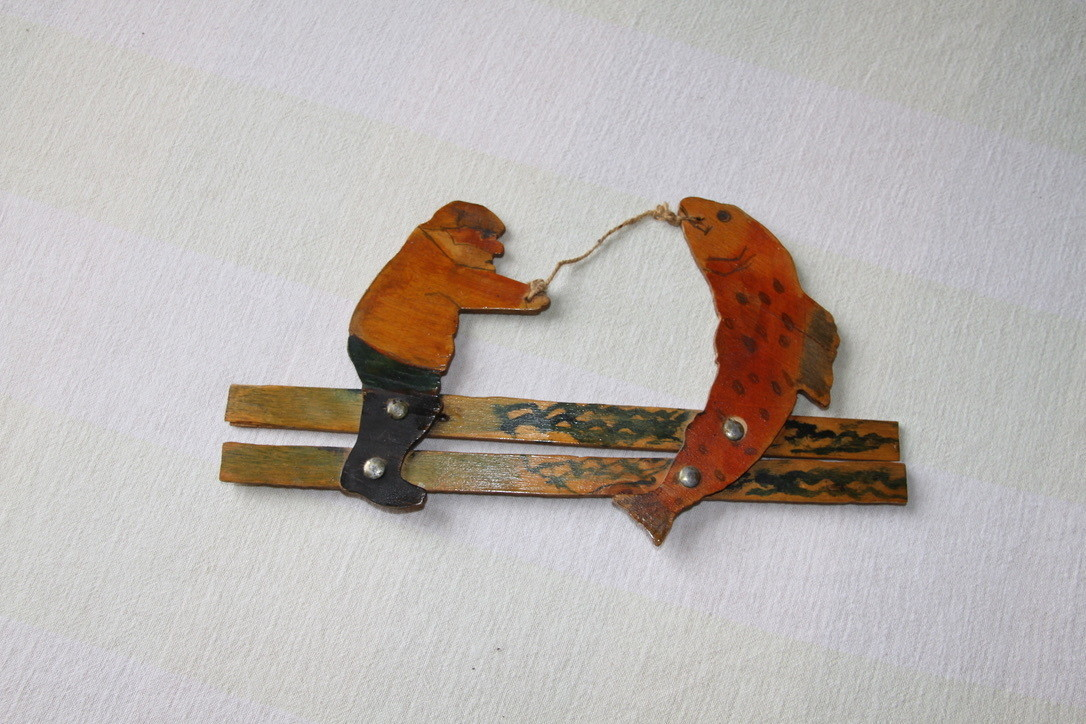 en leke av finer og tau som forestiller en fisker ( " storfiskeren"). Leken er i god stand.