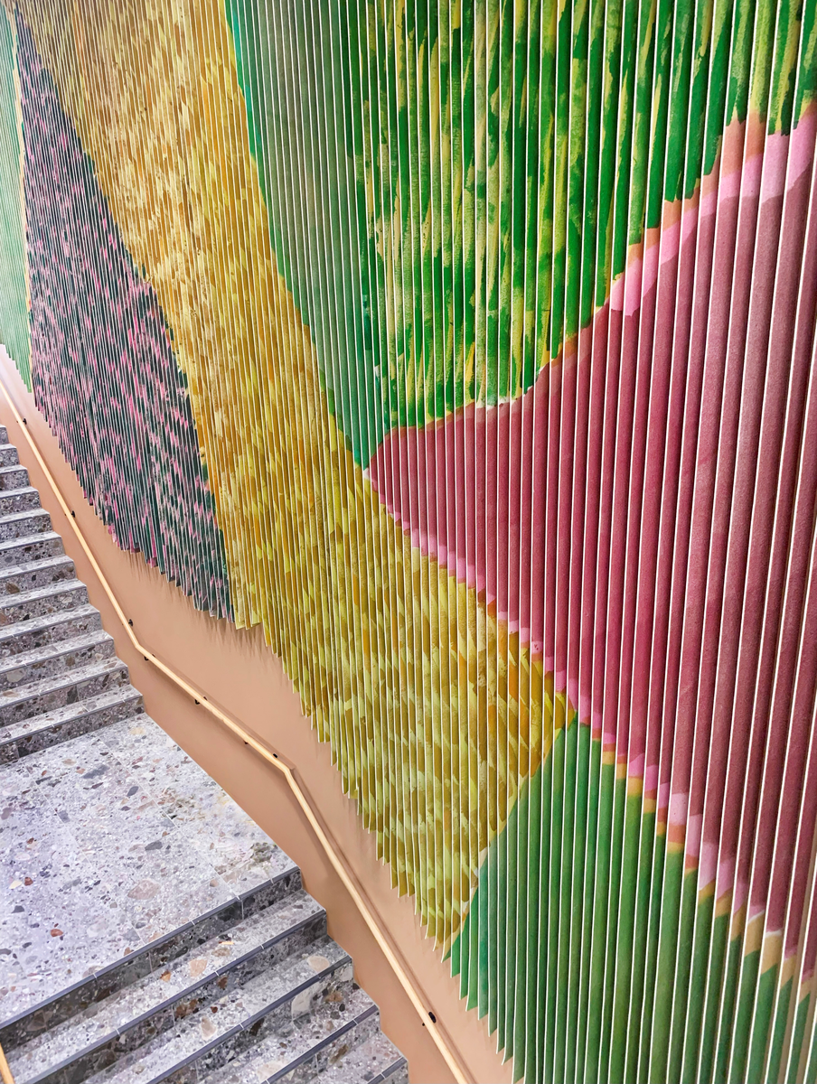 Det flate jordbrukslandskapet i Vestfold er utgangspunkt for Marianne Moes vegghengte tekstil "Landskap i bevegelse". Mengder av tjukk ullfilt er malt med store pensler, sprøytet med farger på begge sider og så skåret opp i remser. Motivet brytes derfor opp, og forandrer seg avhengig av hvor betrakteren står og hvordan hen beveger deg. Det skaper en opplevelse av et skiftende landskap, linjer og fargespill som minner om vårgrønne skoger og modne åkrer.