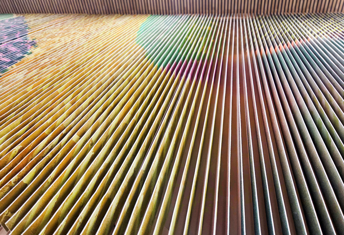 Det flate jordbrukslandskapet i Vestfold er utgangspunkt for Marianne Moes vegghengte tekstil "Landskap i bevegelse". Mengder av tjukk ullfilt er malt med store pensler, sprøytet med farger på begge sider og så skåret opp i remser. Motivet brytes derfor opp, og forandrer seg avhengig av hvor betrakteren står og hvordan hen beveger deg. Det skaper en opplevelse av et skiftende landskap, linjer og fargespill som minner om vårgrønne skoger og modne åkrer.