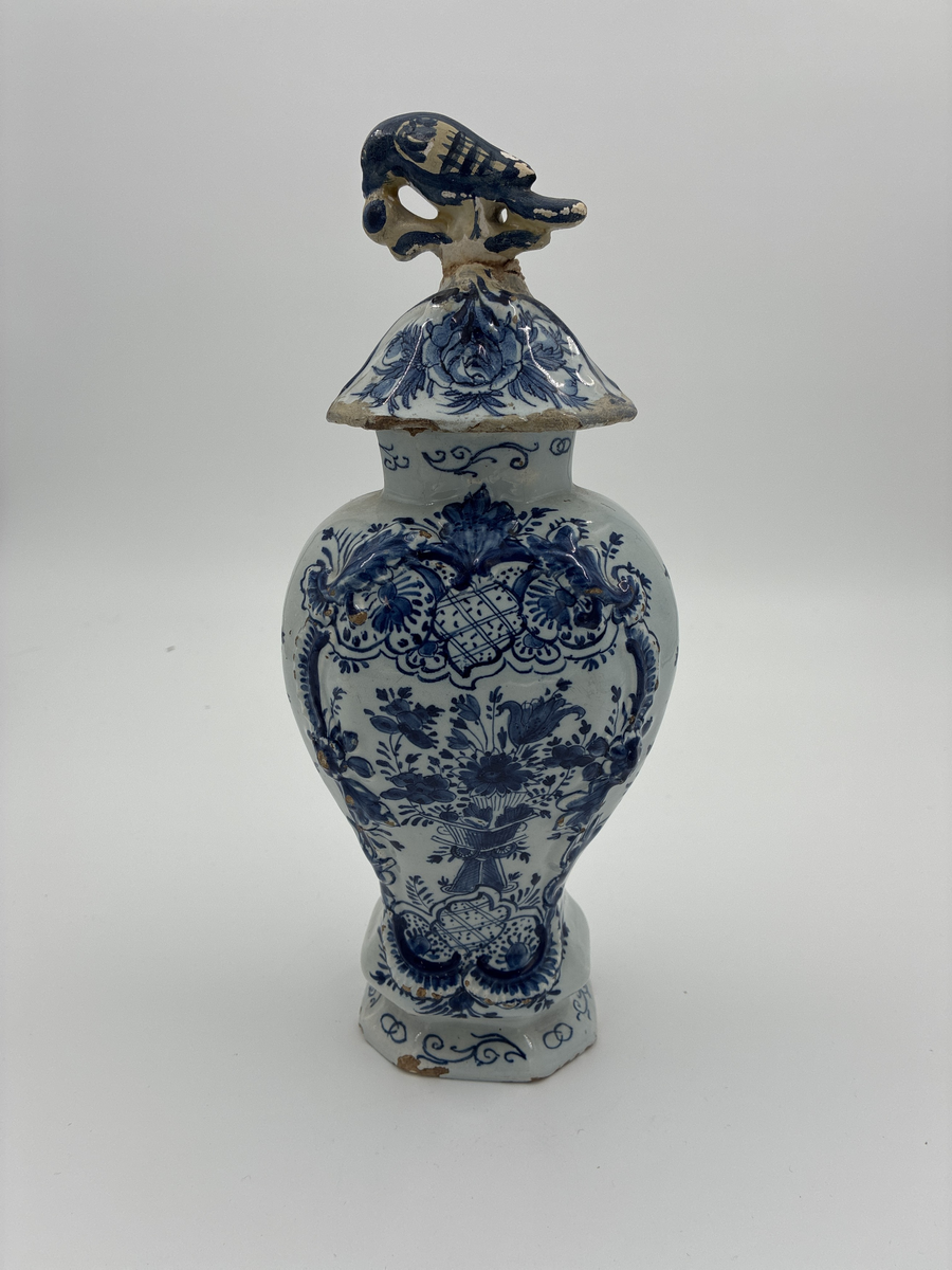 Urna med lock. Av glaserad fajans med dekor i blått. Locket dekorerad med fågel, defekt. Troligen från Delft.