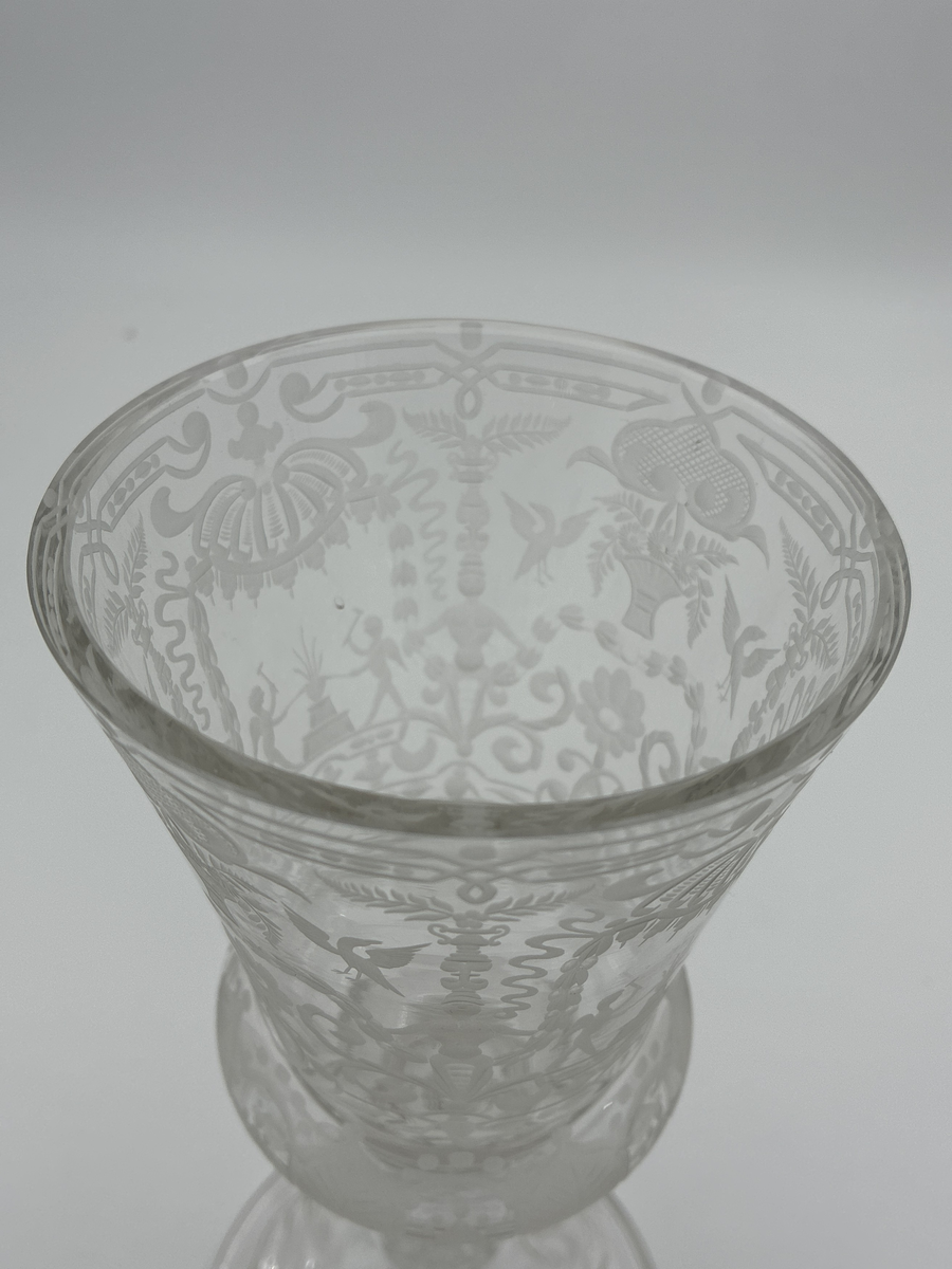 Pokal med lock. Av glas med riklig etsad dekor. 

Enligt säljarens uppgift har pokalen varit en gåva till fru von Proschwitz, Floda herrgård vid dennas 50-årsdag.
Efter hennes bortgång överlämnades pokalen som minnesgåva till dr G. Nystedt för dennas mångåriga tjänst som husläkare hos familjen Proschwitz.