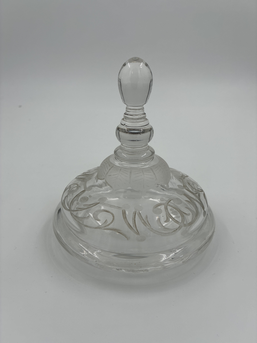 Pokal med lock. Av glas med riklig etsad dekor. 

Enligt säljarens uppgift har pokalen varit en gåva till fru von Proschwitz, Floda herrgård vid dennas 50-årsdag.
Efter hennes bortgång överlämnades pokalen som minnesgåva till dr G. Nystedt för dennas mångåriga tjänst som husläkare hos familjen Proschwitz.