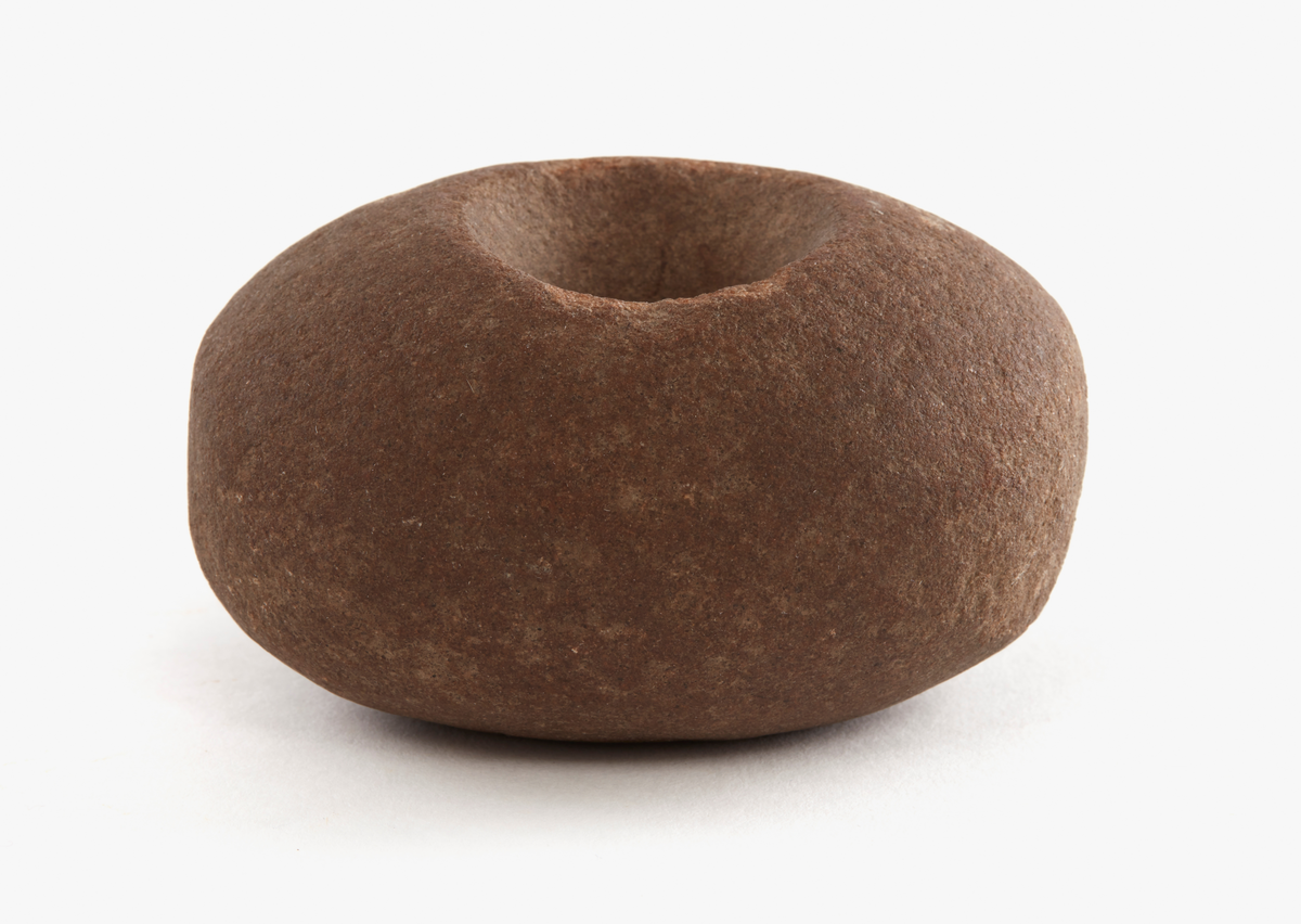 Klubba av granit. Klotfomig med ovalt tvärsnitt. Genomborrad med ett bikoniskt hål 10-35 mm diameter. Slagytor på båda kortändarna.