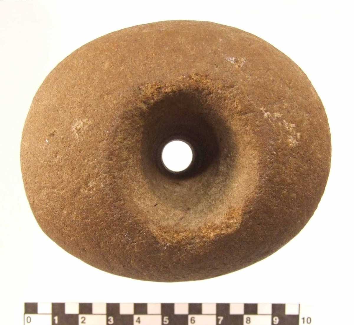 Klubba av granit. Klotfomig med ovalt tvärsnitt. Genomborrad med ett bikoniskt hål 10-35 mm diameter. Slagytor på båda kortändarna.