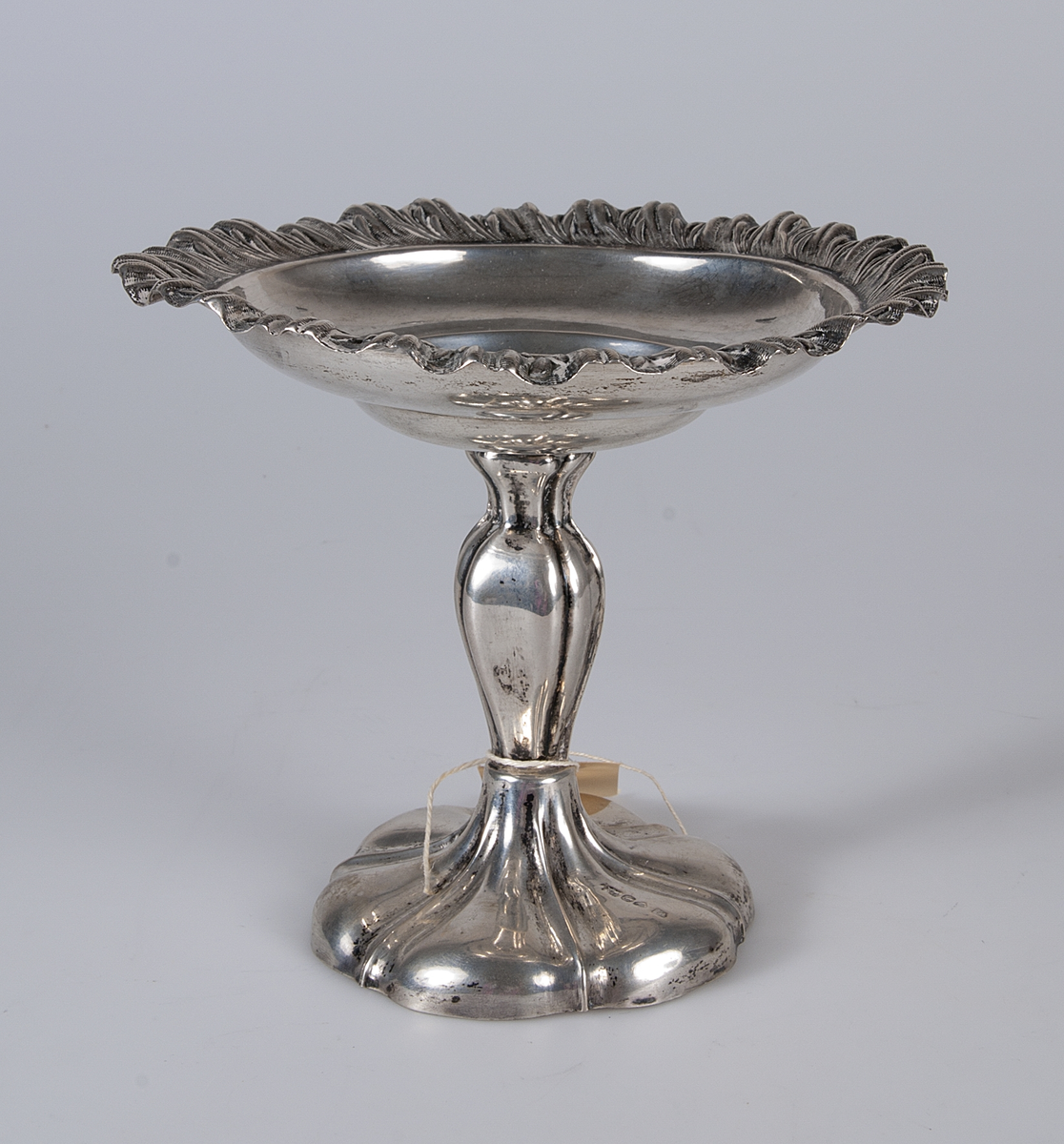 Pressad kant och i skålens botten ett påsatt, pressat och cicelerat ornament i form av frukter och bolad, stämplar: V4, tre kronor, St erik, CN. Foten fylld med gips som varit överdragen med grön filt.