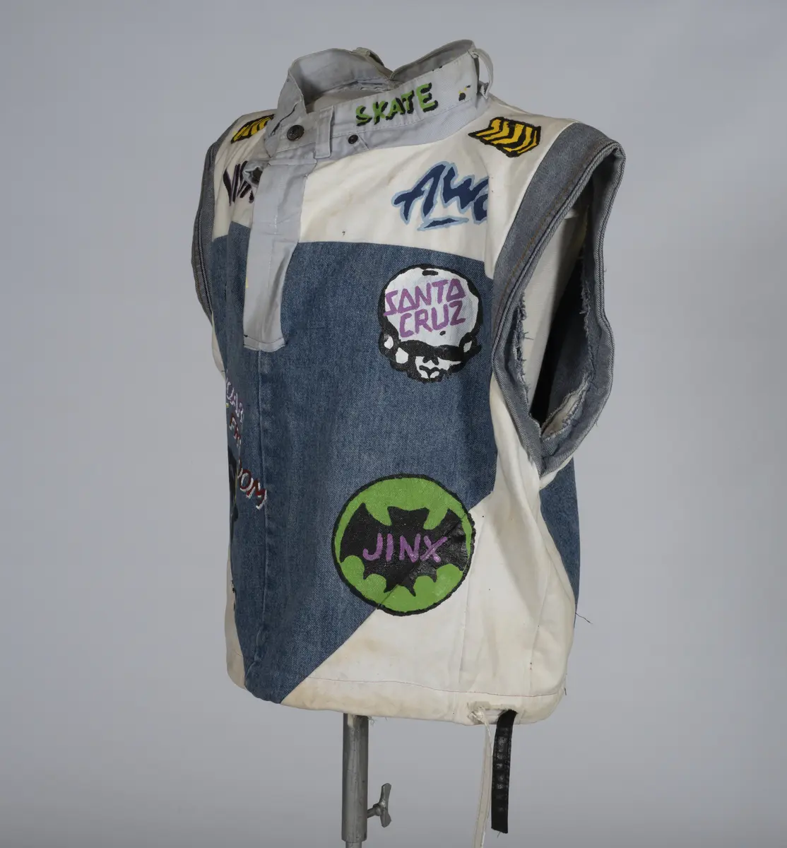 Vest, sydd av gamle olabukser og dekorert med maling.

Håndsydd og maskinsydd. Blant dekoren er mange kjente merker for produsenter av skateboardutstyr. En button for filmen "Ghostbusters II" fra 1989 sitter også på vesten.