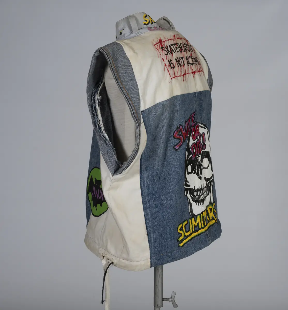 Vest, sydd av gamle olabukser og dekorert med maling.

Håndsydd og maskinsydd. Blant dekoren er mange kjente merker for produsenter av skateboardutstyr. En button for filmen "Ghostbusters II" fra 1989 sitter også på vesten.