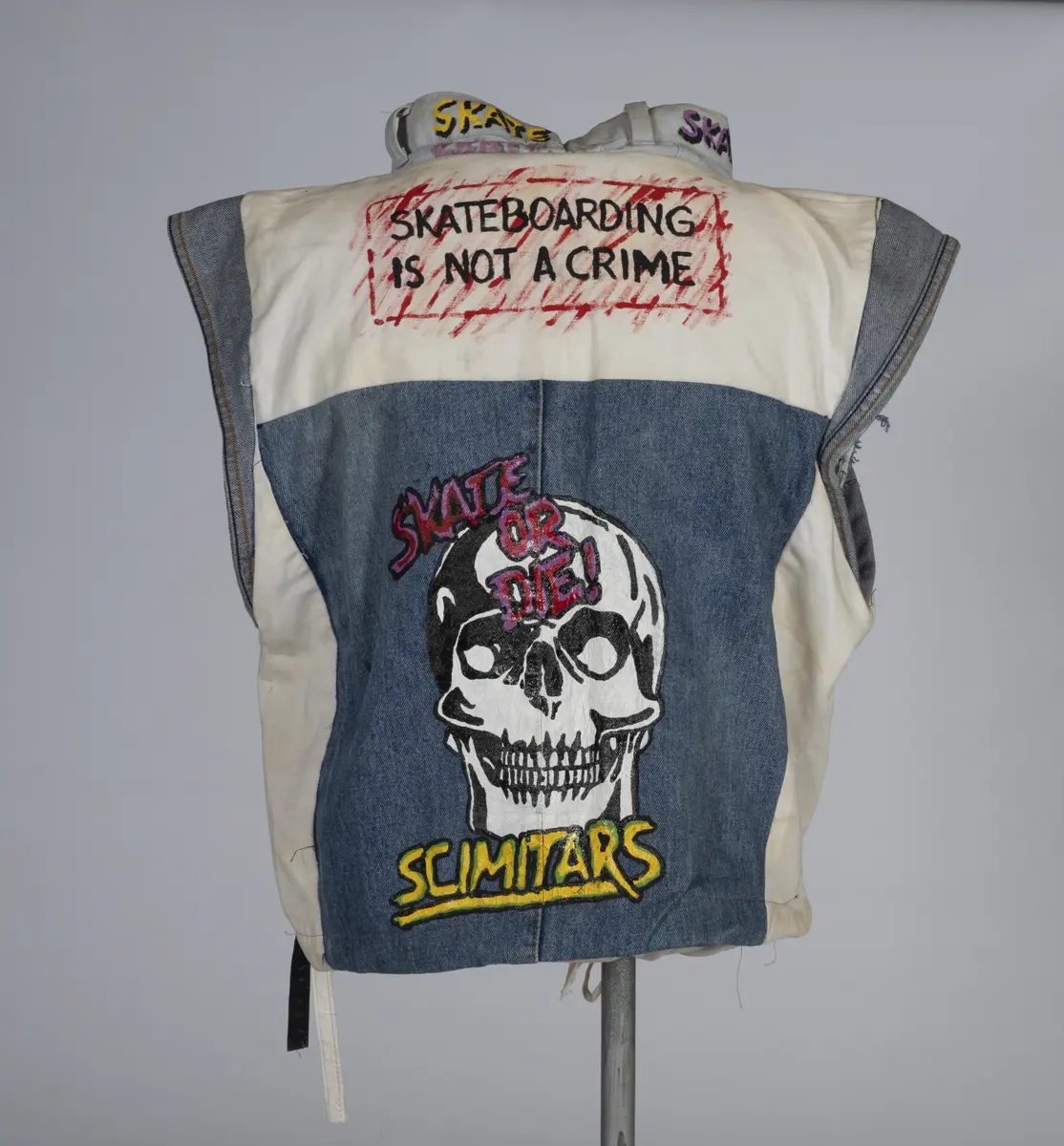 Vest, sydd av gamle olabukser og dekorert med maling.

Håndsydd og maskinsydd. Blant dekoren er mange kjente merker for produsenter av skateboardutstyr. En button for filmen "Ghostbusters II" fra 1989 sitter også på vesten.