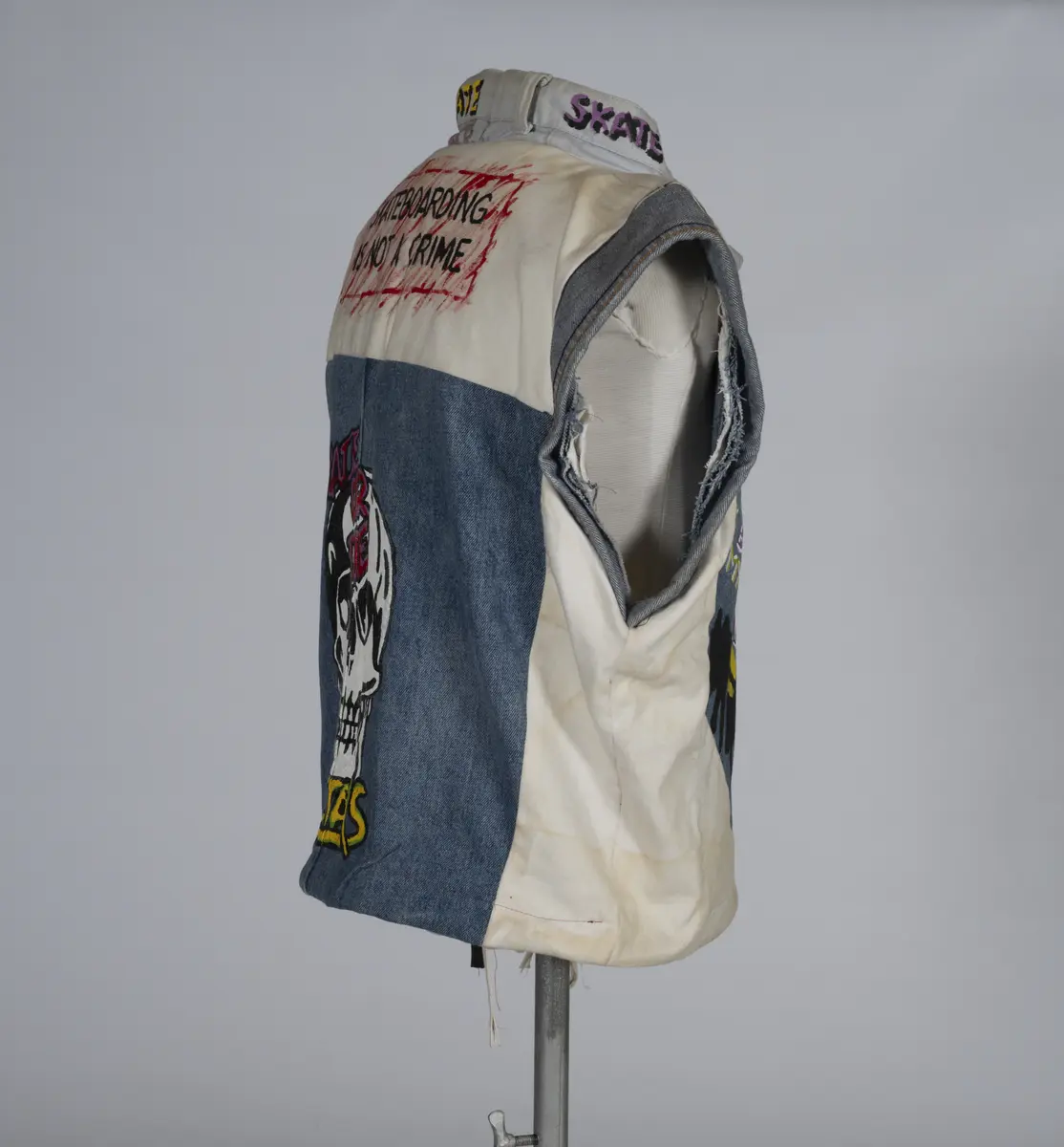 Vest, sydd av gamle olabukser og dekorert med maling.

Håndsydd og maskinsydd. Blant dekoren er mange kjente merker for produsenter av skateboardutstyr. En button for filmen "Ghostbusters II" fra 1989 sitter også på vesten.