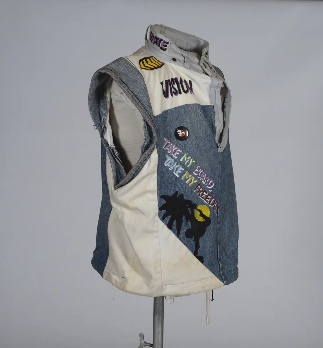 Vest, sydd av gamle olabukser og dekorert med maling.

Håndsydd og maskinsydd. Blant dekoren er mange kjente merker for produsenter av skateboardutstyr. En button for filmen "Ghostbusters II" fra 1989 sitter også på vesten.