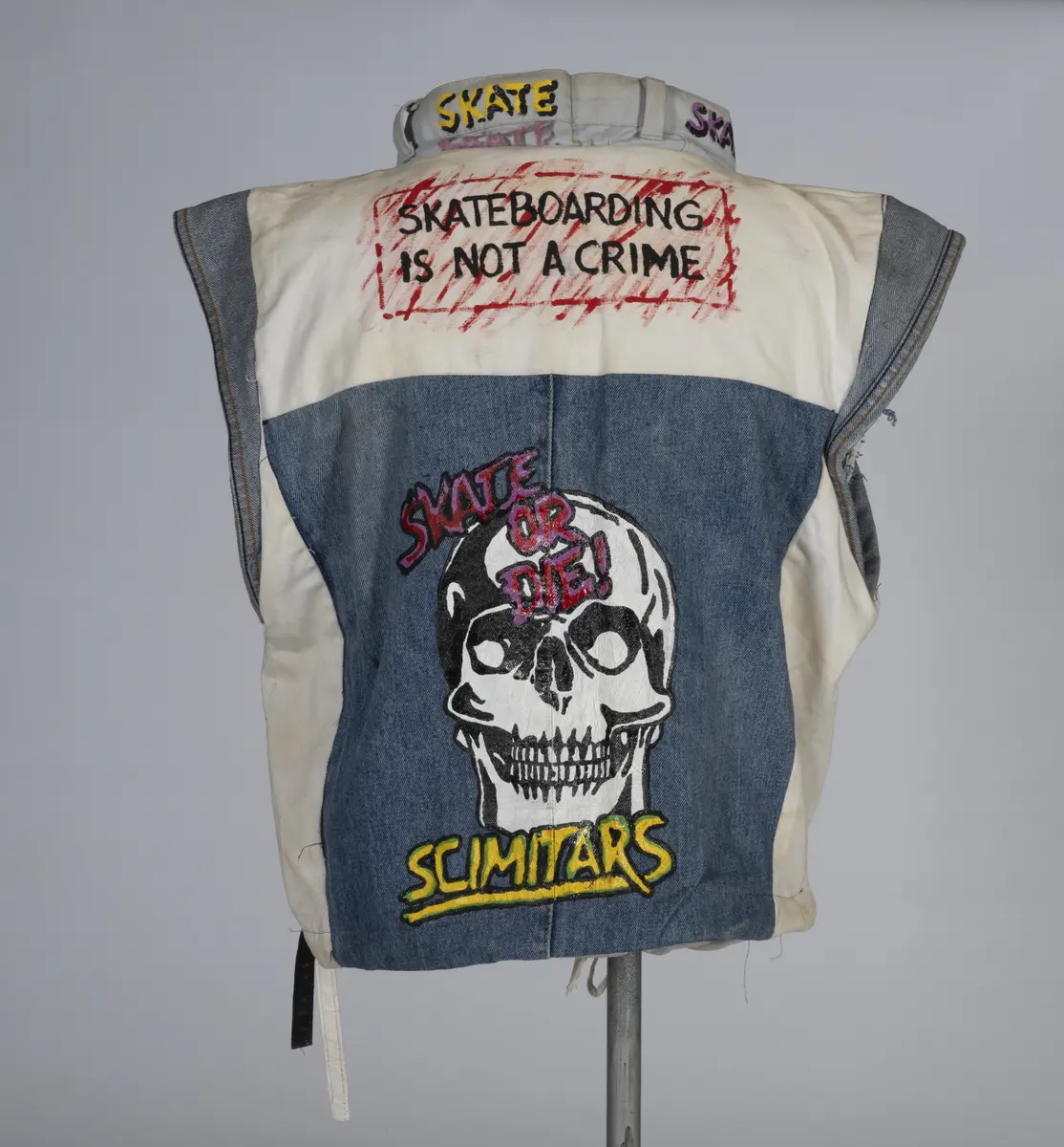 Vest, sydd av gamle olabukser og dekorert med maling.

Håndsydd og maskinsydd. Blant dekoren er mange kjente merker for produsenter av skateboardutstyr. En button for filmen "Ghostbusters II" fra 1989 sitter også på vesten.