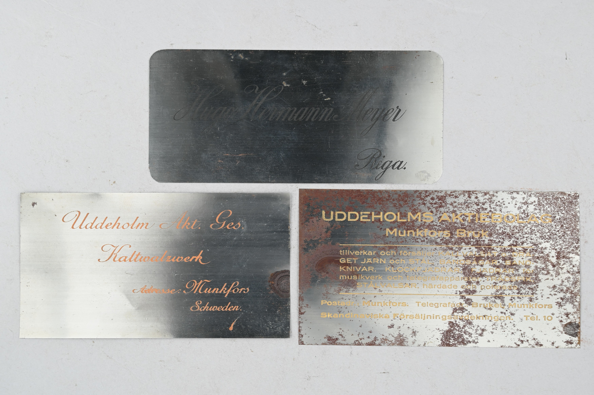 12 prover på kallvalsad plåt. Tillverkade vid Munkfors bruk, Uddeholms AB. Tillhörande lapp med samma notering. Olika märkning på plåtarna där sju av de har notering: "Uddeholm Akt. Ges Kaltwalzwerk, Adresse: Munkfors, Schweden.", fyra av plåtarna har notering: "Uddeholms Aktiebolag, Munkfors bruk tillverkar och försäljer kallvalsat o. draget järn och stål, bandsågar, bandknivar, klockfjädrar, fjädrar för musikverk och telegrafapparater, trådspik, stålvalsar, härdade och polerade. Postadr: Munkfors. Telegrafadr: Bruket, Munkfors Skandinaviska Försäljningsavdelningen. Tel. 10.", samt en plåt med notering: "Hugo Hermann Meyer, Riga. Maschinen und technische Artikel ohne Ausnahme jeder Art. Die Firma besteht seit 1873."