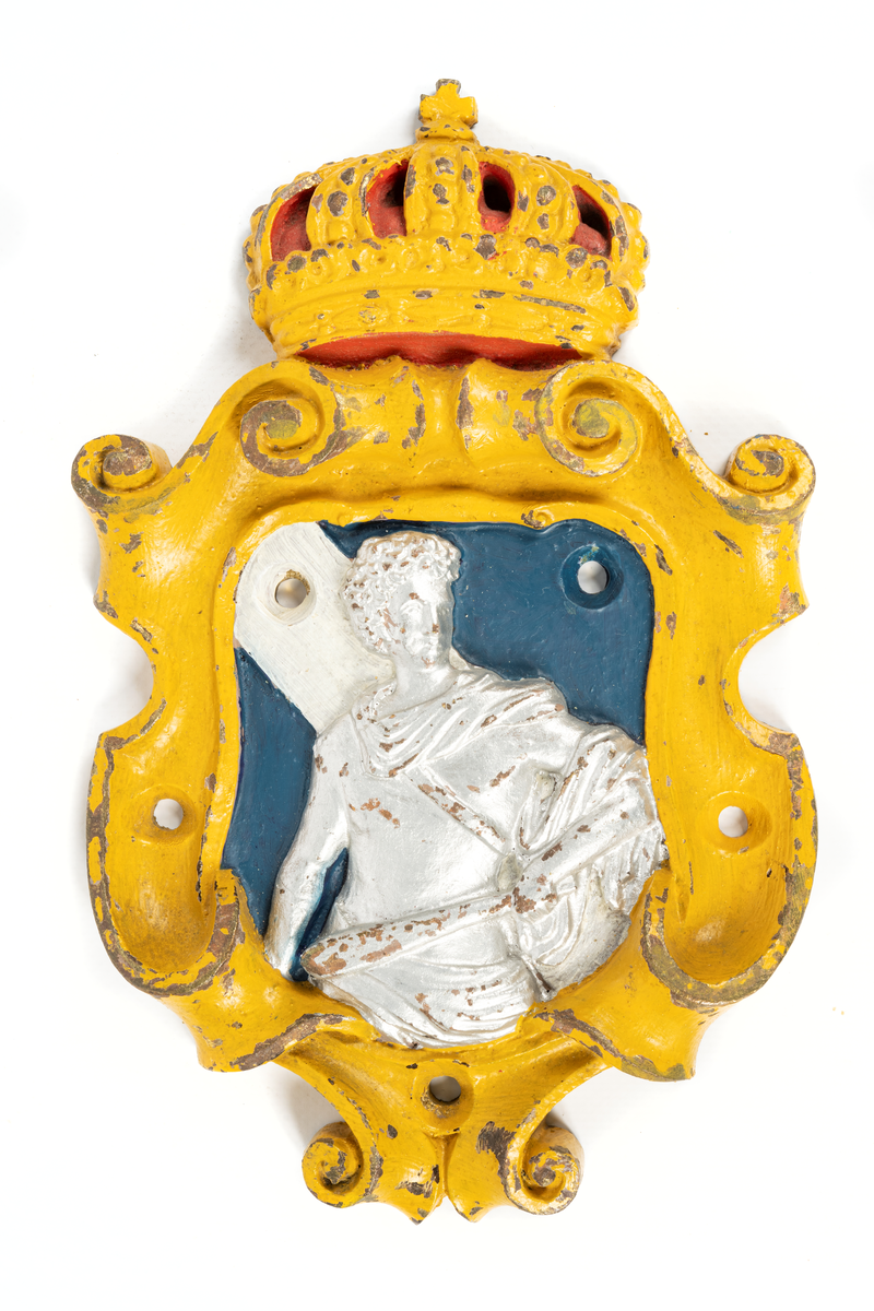 Består av sköld med krona, inom skölden på blå botten mansfigur, bronserad i vitt och i handen hållande en klubba. Sköldens kanter målade i gult, kronan i gult och rött.