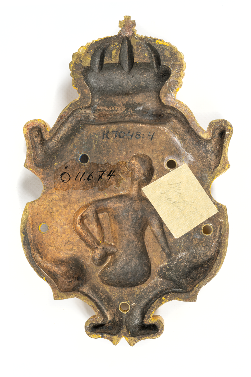 Består av sköld med krona, inom skölden på blå botten mansfigur, bronserad i vitt och i handen hållande en klubba. Sköldens kanter målade i gult, kronan i gult och rött.