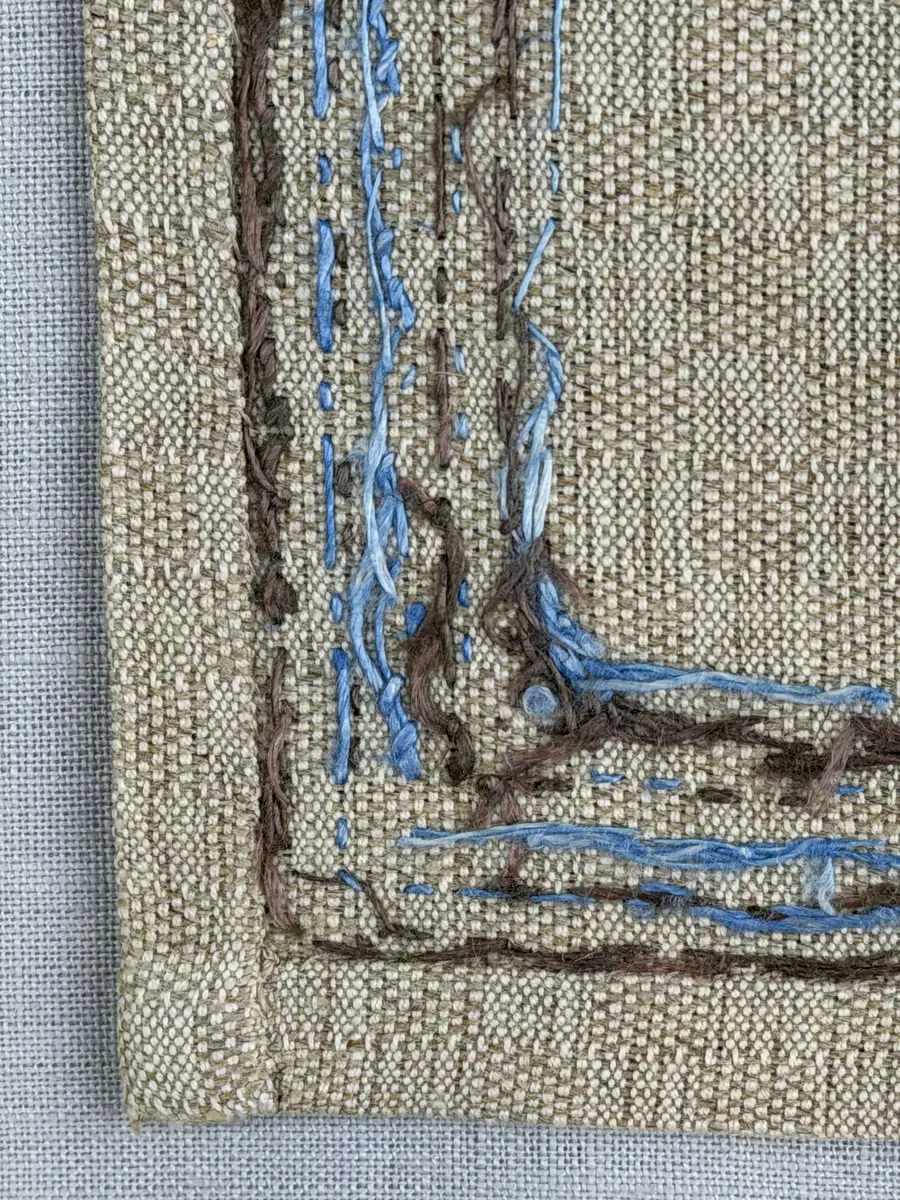 Bordsduk gjord av handvävt linnetyg i sålldräll och broderi utfört med lintråd i rätvinkligt lagda förstygn översydda med läggsöm samt knutar. 
Duken har raka hörn och 12mm breda dubbelvikta fållar runt om, som är fastsydda med smygstygn. 