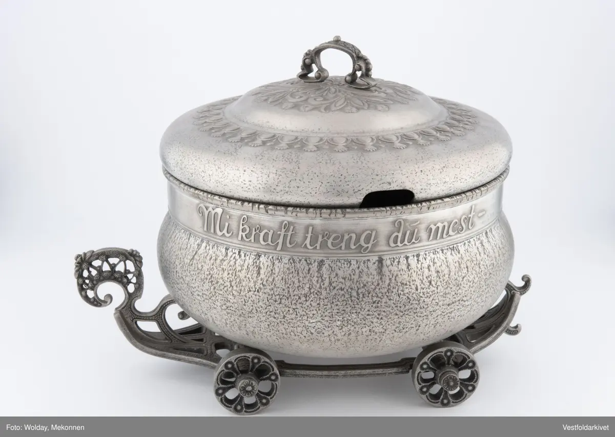 En terrin med lokk. Den har hjul slik at den kan "kjøre" bortover bordet.