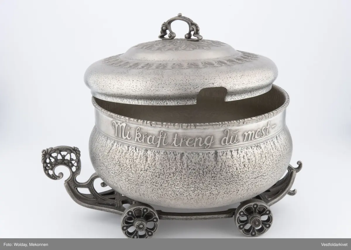 En terrin med lokk. Den har hjul slik at den kan "kjøre" bortover bordet.