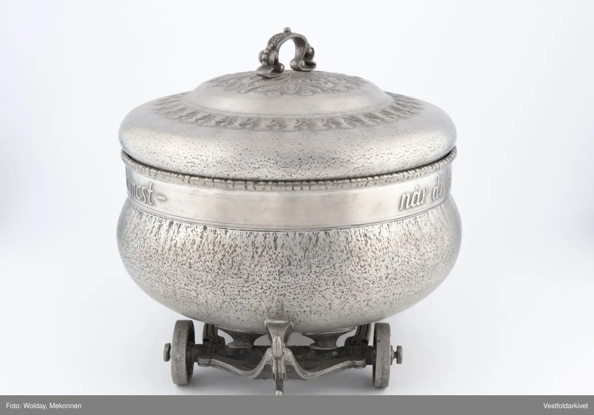 En terrin med lokk. Den har hjul slik at den kan "kjøre" bortover bordet.