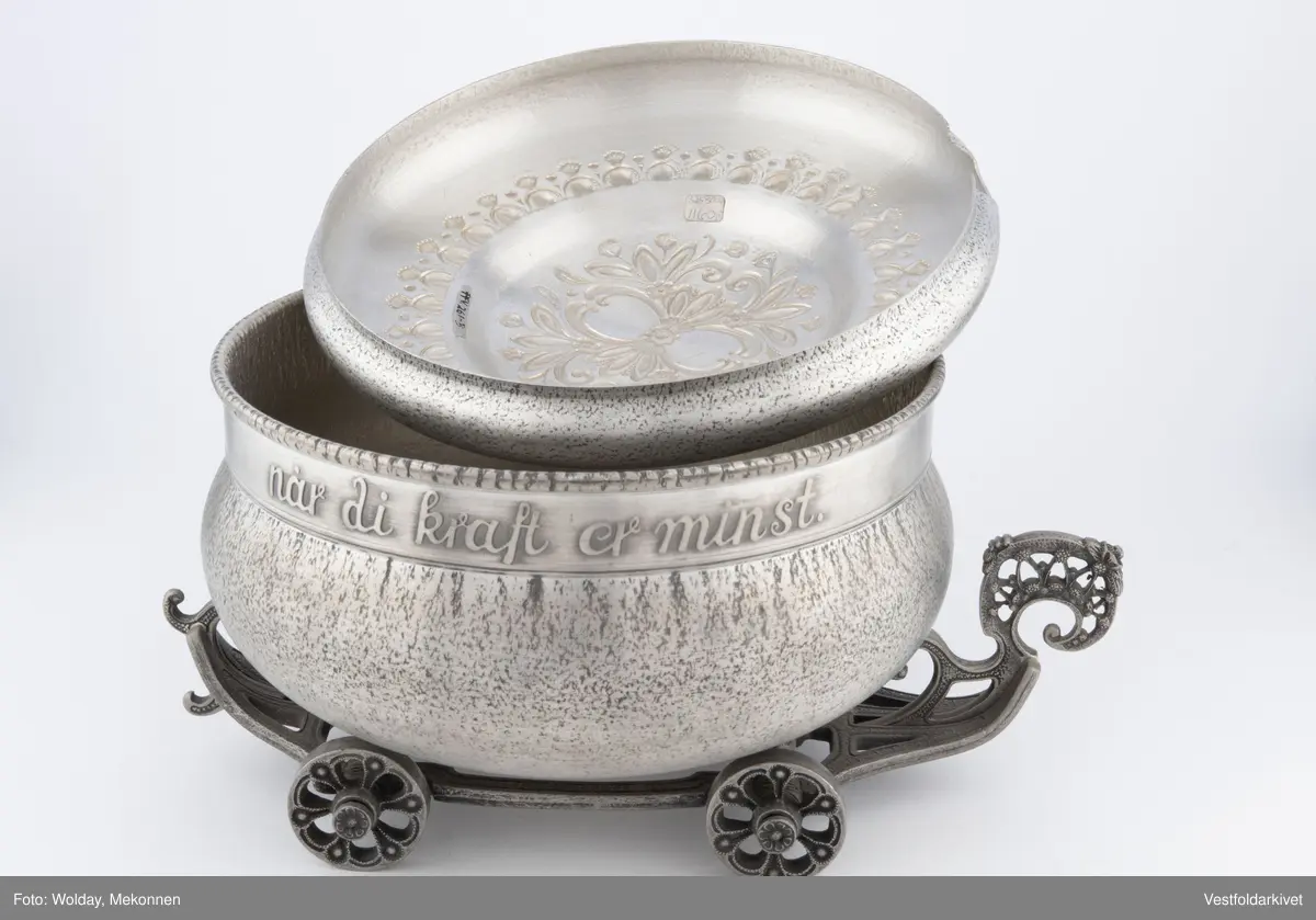 En terrin med lokk. Den har hjul slik at den kan "kjøre" bortover bordet.