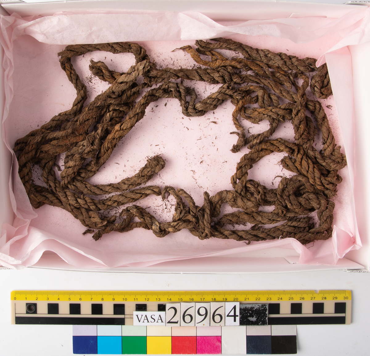 Däcksplanka.
Åtta genomgående spikhål på vardera sida av plankan. Två ej genomgående hål i ena änden. Spikhålen är original från när skeppet byggdes. Originalspikarna är bortrostade. Efter bärgningen monterades däcksplankan med rostfri fransk träskruv samt bricka. Vid demonteringen 2023 lossades alla skruvar. De brickor som gick att ta bort togs bort. En del satt så djupt i träet att det inte gick att demontera dem utan att skada plankan. Dessa brickor fick därför sitta kvar. 
Tydliga avtryck från balkar samt huggmärken på undersidan. Spår av en kvist där ett parti saknas på undersidan.