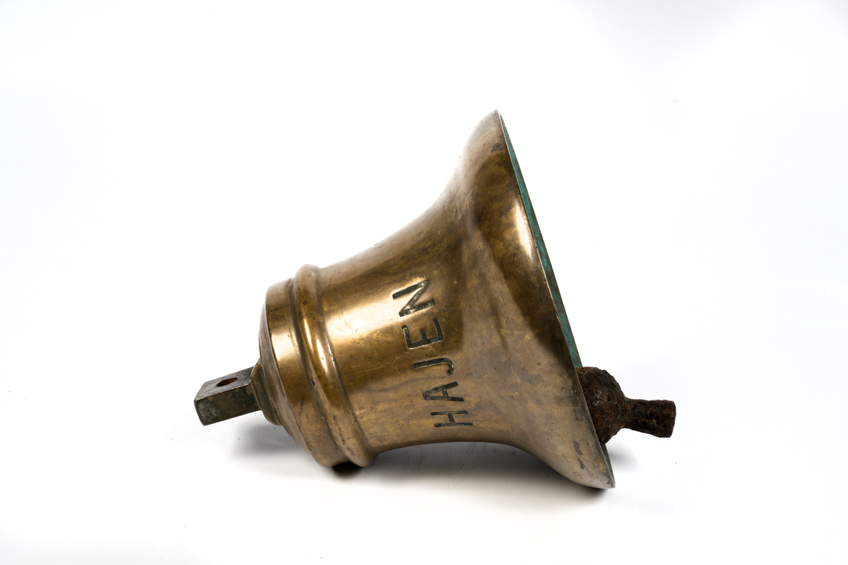 Skeppsklocka av malm, grönmålad med kläpp av järn.