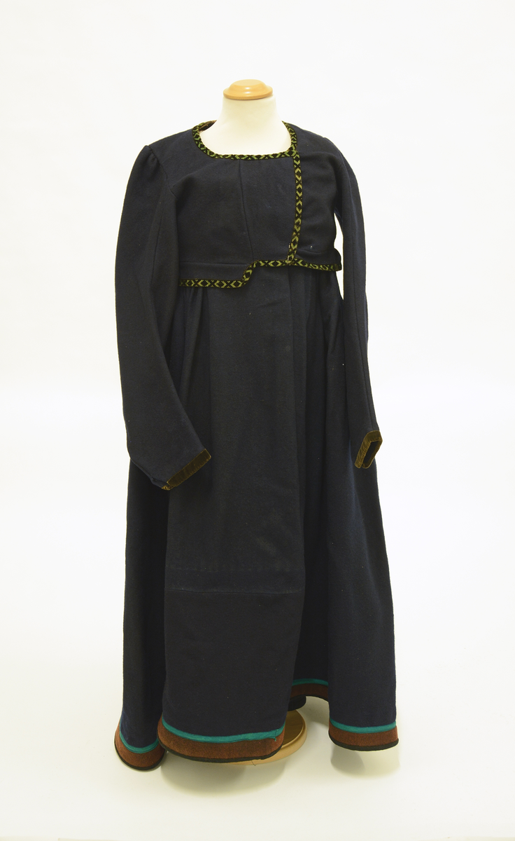 Drakt som består av
 A) overdel,
 B) stakk,
 C) trøye og
 D) forkle. 
Opplysninger fra protokollen: 
b) Stakk av blaatt vadmaal, skoren i 5 breiddir, smaarykt, med stiv kanting og skoning nede, borda ei brun vadmaalsstrime med grønt skillingsband. Til stakken høyrer heimevovne, brogda selar. ( Sekundært påsydd skoning med svart vadmel)
c) Trøye av blaatt vadmaal kanta med grøne og svartmynstra fløyelsborder (paa ermane svart fløyelskant). Trøyeblokune er skorne paa lag som uppluten, hev ei smal rispe nede bak, med 2 lask, og er til aa hekte framme. Dei tviblokka ermane hev litt rykkjing ved herdi og smaa stigle paa ermi framme. Sidd bak ikr. 29 cm
d) Bomullsfyrklæde med brogda fyrklædebunad, fyriklædet er graabrunt med strimur av svarte rankur fyldte med ljosare triblad. Sidd ikr. 1 m.