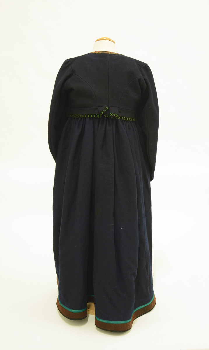 Drakt som består av
 A) overdel,
 B) stakk,
 C) trøye og
 D) forkle. 
Opplysninger fra protokollen: 
b) Stakk av blaatt vadmaal, skoren i 5 breiddir, smaarykt, med stiv kanting og skoning nede, borda ei brun vadmaalsstrime med grønt skillingsband. Til stakken høyrer heimevovne, brogda selar. ( Sekundært påsydd skoning med svart vadmel)
c) Trøye av blaatt vadmaal kanta med grøne og svartmynstra fløyelsborder (paa ermane svart fløyelskant). Trøyeblokune er skorne paa lag som uppluten, hev ei smal rispe nede bak, med 2 lask, og er til aa hekte framme. Dei tviblokka ermane hev litt rykkjing ved herdi og smaa stigle paa ermi framme. Sidd bak ikr. 29 cm
d) Bomullsfyrklæde med brogda fyrklædebunad, fyriklædet er graabrunt med strimur av svarte rankur fyldte med ljosare triblad. Sidd ikr. 1 m.