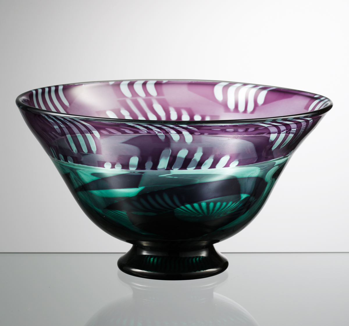 Graalskål, klockformad med svart, låg fot. Violett och ljusturkos dekor.
Formgivare: Eva Englund.