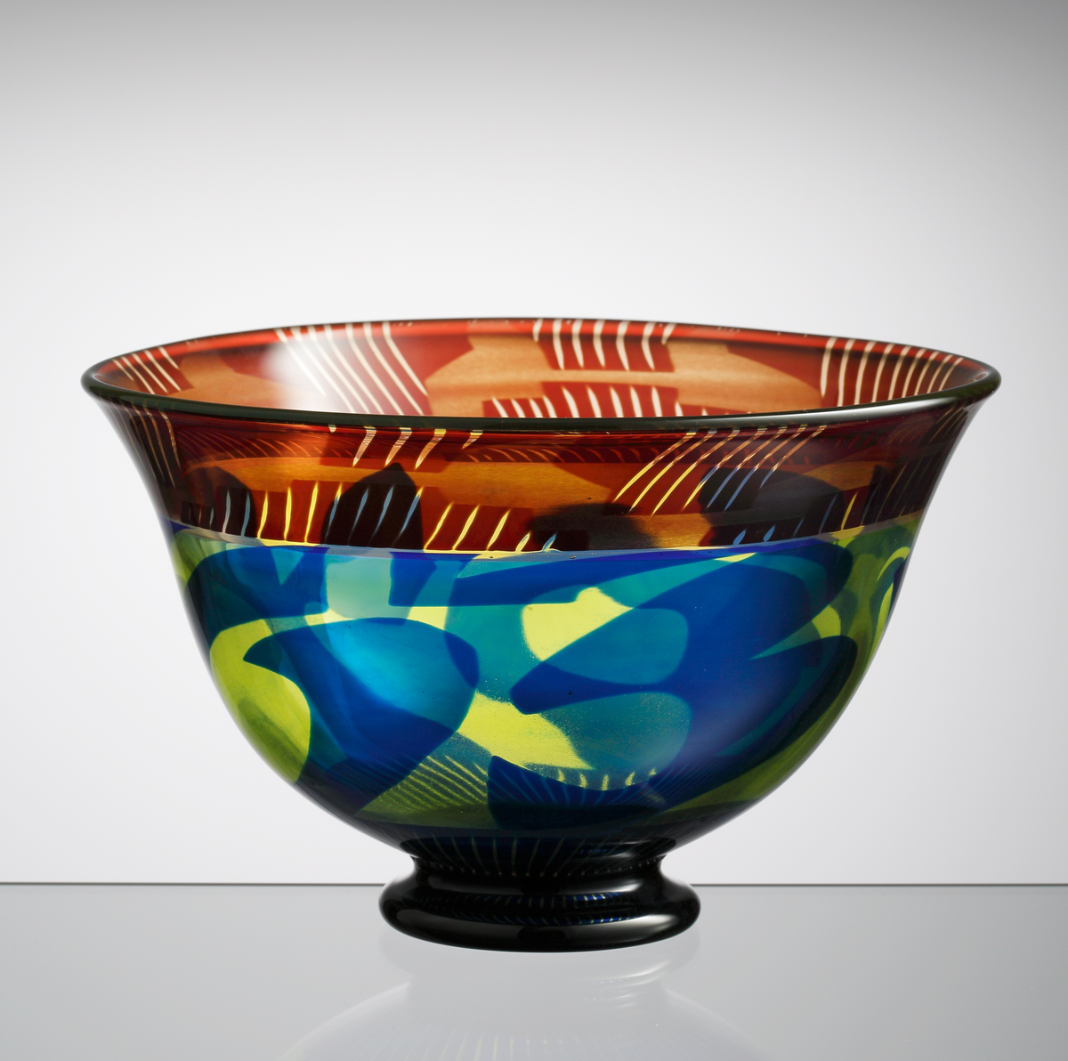 Graalskål, klockformad med svart, låg fot. Dekor i rubinrött, blått och gult.
Formgivare: Eva Englund.