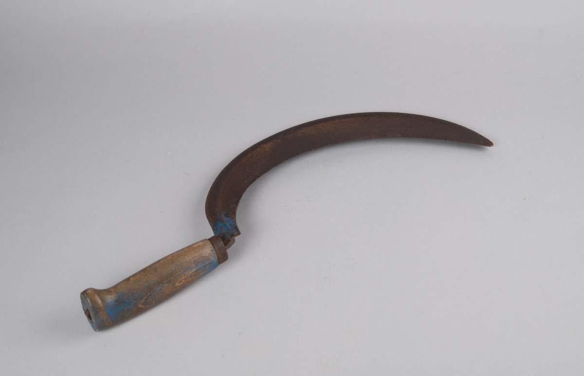Form: rett åpen sigdform. Håndtak med håndstøtte i enden, og liten jernholk øverst. Bladets 'hale' går gjennom hele håndtaket og 'låses' i enden av dette. Rester av blåmaling på håndtak og gullbronse-stafferingen på bladet