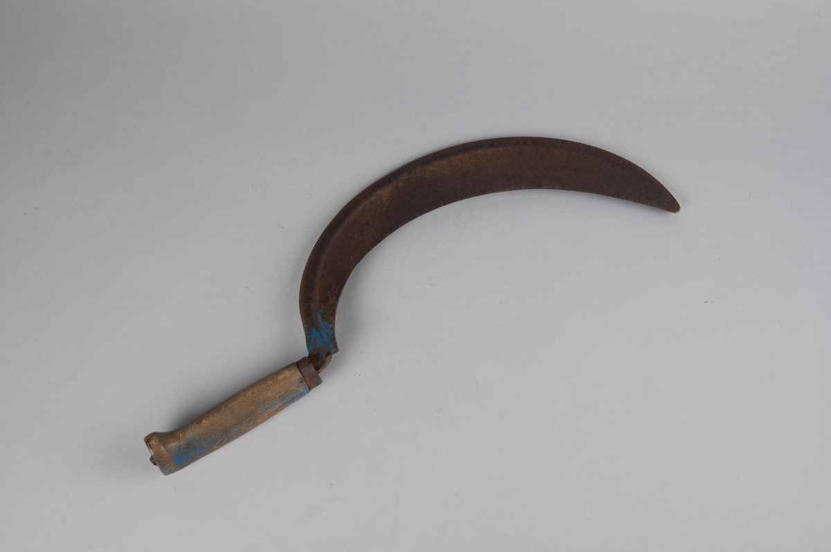 Form: rett åpen sigdform. Håndtak med håndstøtte i enden, og liten jernholk øverst. Bladets 'hale' går gjennom hele håndtaket og 'låses' i enden av dette. Rester av blåmaling på håndtak og gullbronse-stafferingen på bladet