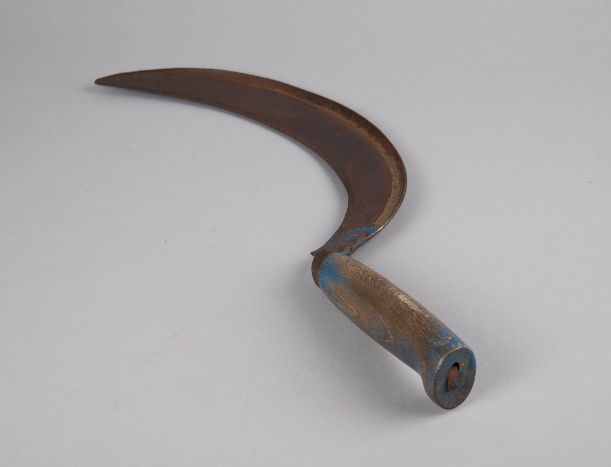 Form: rett åpen sigdform. Håndtak med håndstøtte i enden, og liten jernholk øverst. Bladets 'hale' går gjennom hele håndtaket og 'låses' i enden av dette. Rester av blåmaling på håndtak og gullbronse-stafferingen på bladet