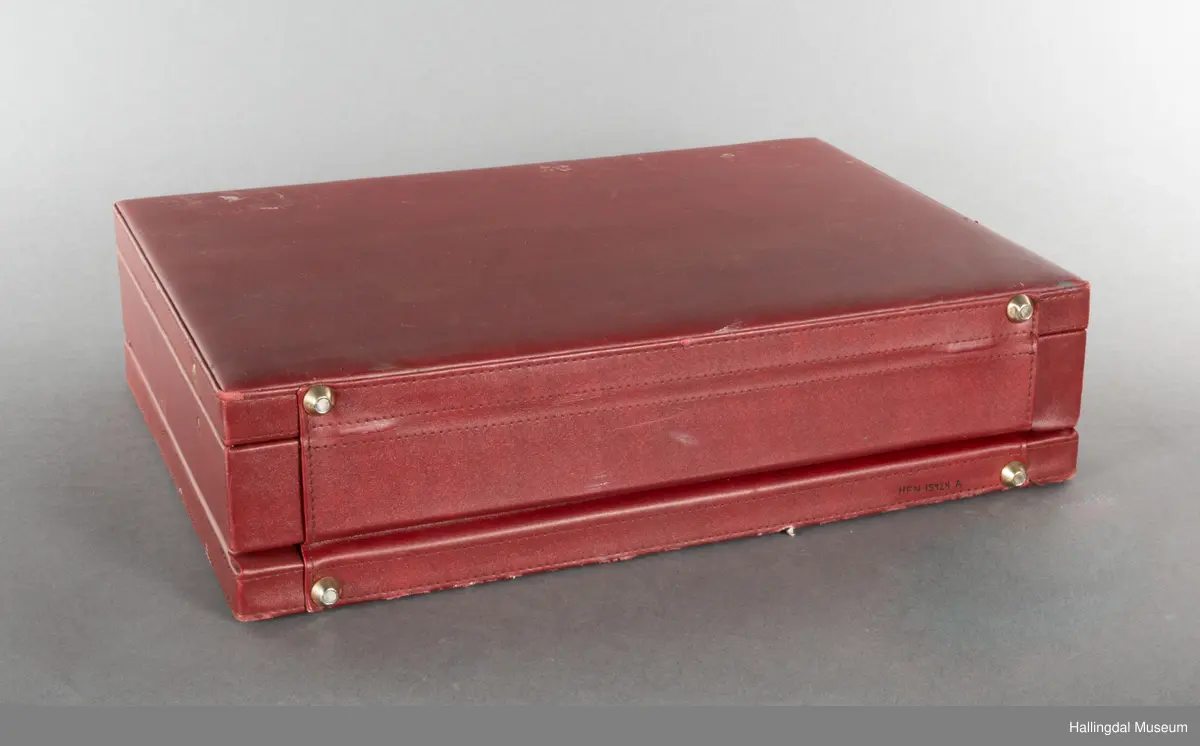 Hjemmelaget transportabelt lydanlegg. Rødbrun skinnkoffert med messingbeslag. Lysebrunt skinn innvendig fôr. Inneholder en ombygd "Mosfet" amplifier i lilla farge, med tilhørende grå strømkabel. På sidene er det plexiglass. Høyre side plexiglass bestående av strøminntak kontakt og en av og på bryter og to stk. merket mikserinngang til jack. På venstre side plexiglass inntak med merke: 12V - DG og to høytalerinnganger. Kabler til høytaler og mikrofon mangler.  