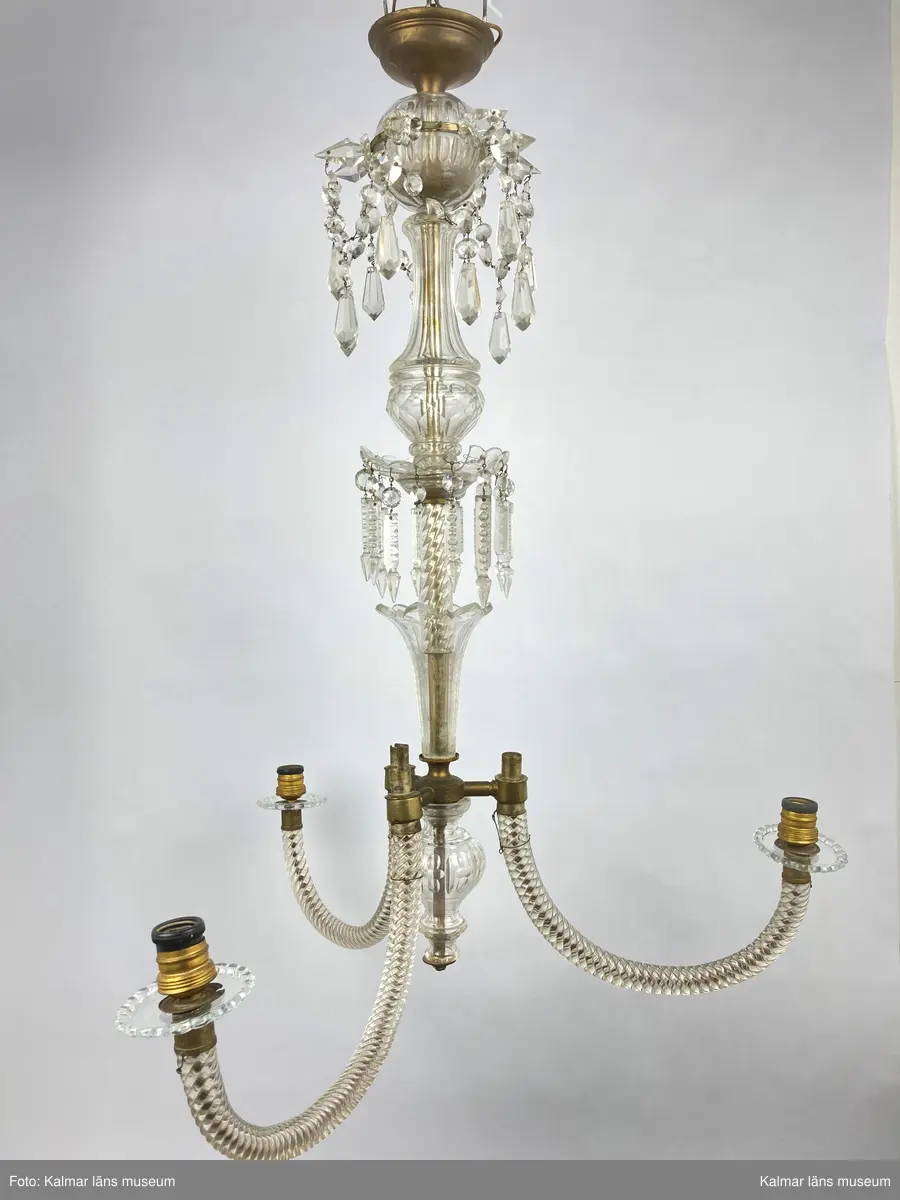 KLM 46969:2. Ljuskrona. Venetiansk stil. Stomme av mässing, övriga detaljer av slipat glas i olika former. Elektrifierad. Utbytta ljusmanschetter. Till ljuskronan hör diverse lösa delar, se KLM 46969:4.