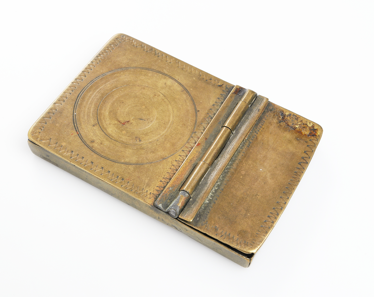 Fickspegel och tillhörande finkam i metall. I hopfällbart etui, av mässing.