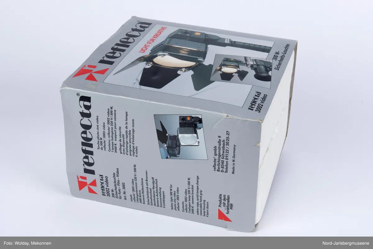 Videolys i original emballasje; isoporboks med pappomslag. Videolampen er i sort metall ledning, . Eske med ekstra halogenpærer medfølger (tom). Pappomslaget med foto av lampen invendig, med teknisk info.
Manual med veiledning på fire språk.