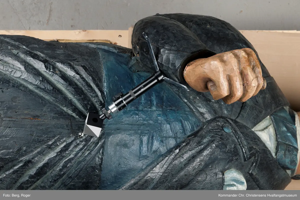 Sortkledd mann med stiv snipp. Bakkenbart, kinnskjegg uten forbindelse med hakeskjegg eller bart.