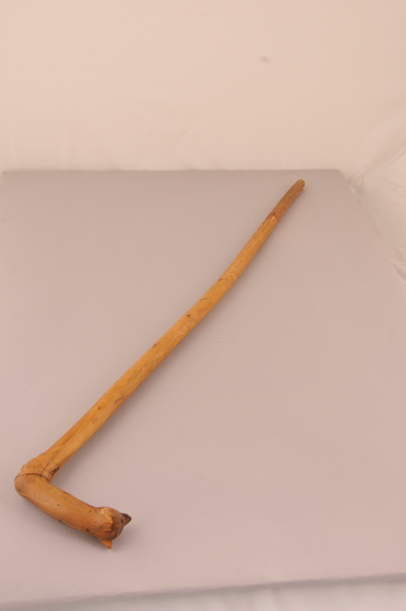 Spaserstokk med utskore ansikt og bjørnemaske på handtaket.