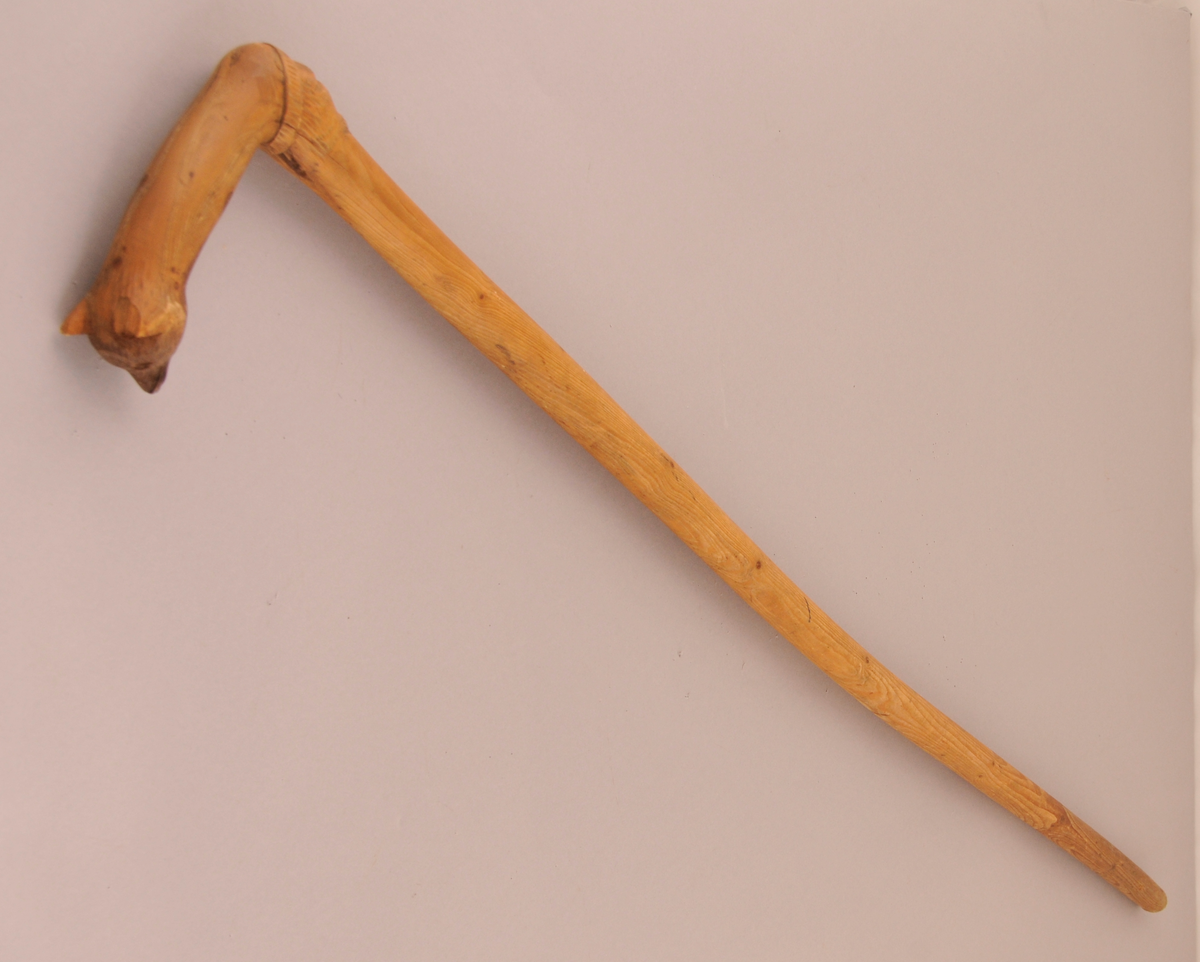 Spaserstokk med utskore ansikt og bjørnemaske på handtaket.