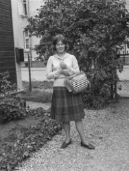 Kvinne i foldeskjørt med veske i bambusspiler.