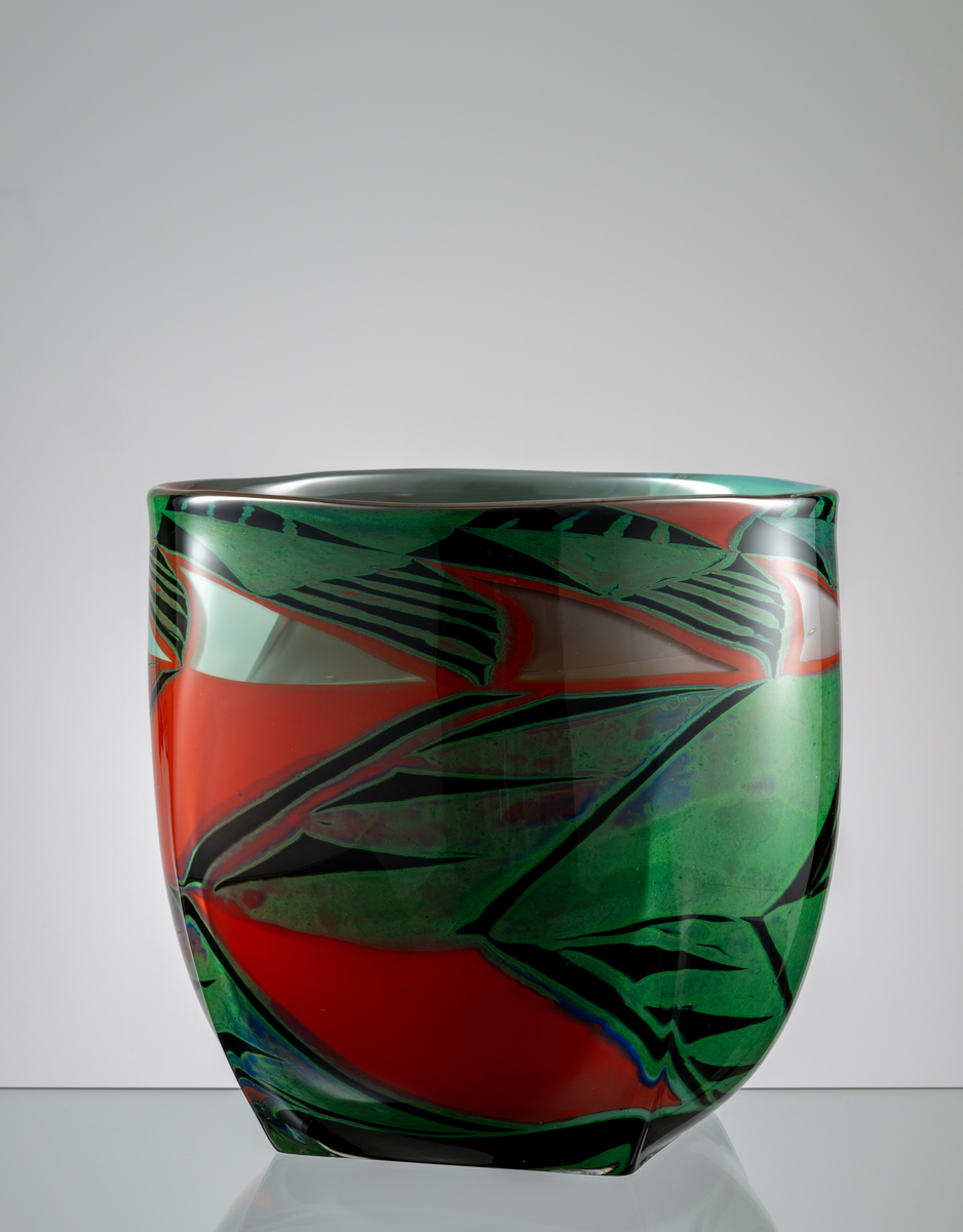 "Poncho" Formgivare: Eva Englund. Graalvas, närmast cylindriskform med kvadratisk botten. Grafisk dekor i röd, svart, turkos och grön nyans.