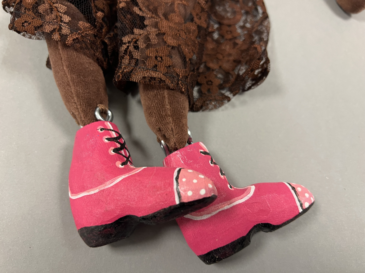 Marionettdockan är tillverkad av material som blivit över från andra projekt, ull (tovad), broderigarn, tygbitar, trä från tillverkarens trädgård. Det mesta handgjort, (tovat, sytt, broderat, skruvat och borrat.