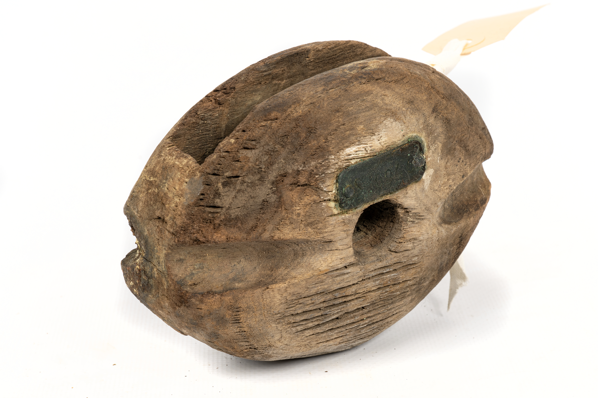 Block hugget ur ett stycke, oval med väl rundade kanter.Skölpad kip för stropp. Skiva med lös tränagel.