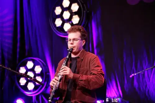 Jonas Støre står på ei scene og spelar på klarinett