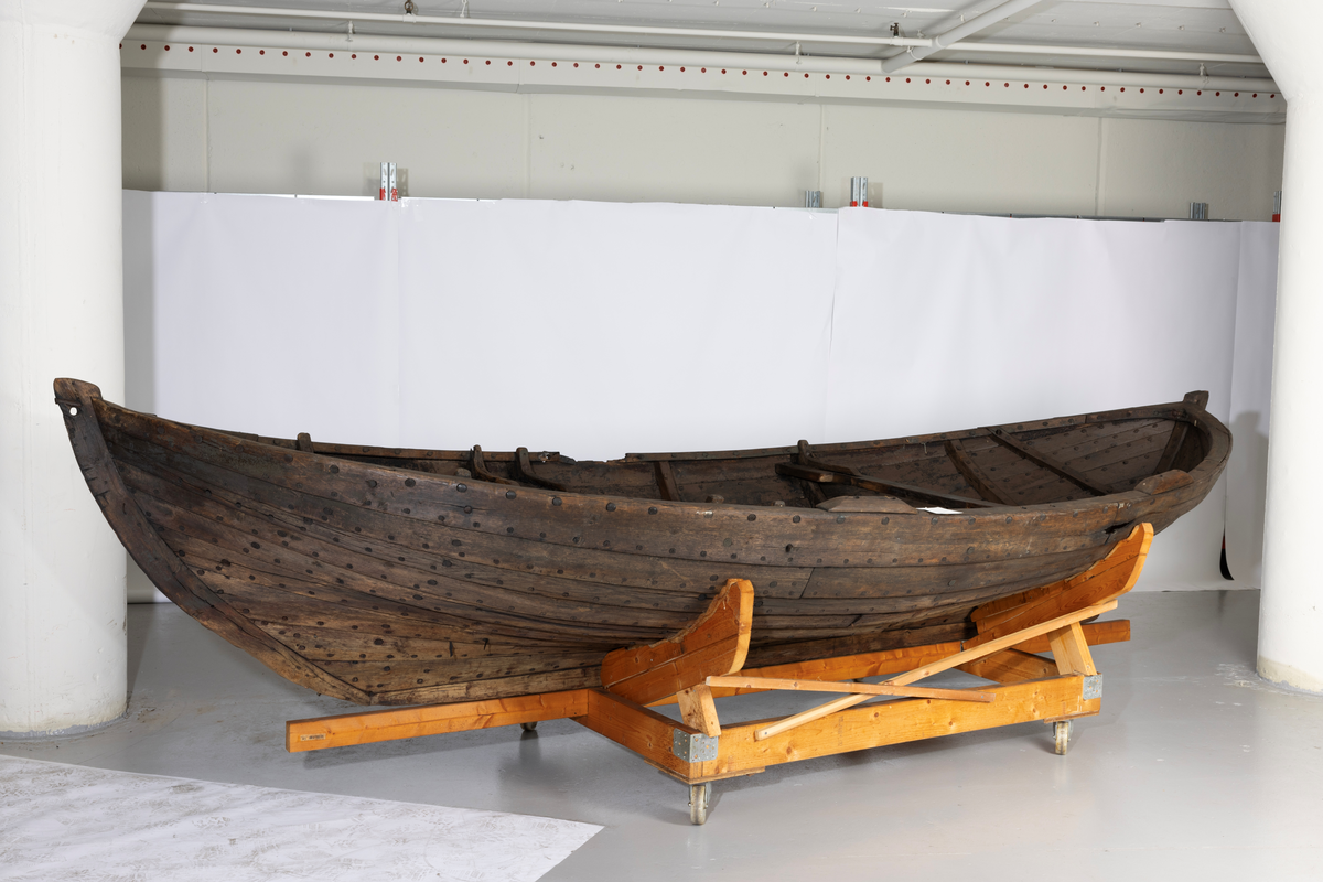 Sørøstnorsk ro- og seilsjekte av eldre type. Såkalt mellombåt. 1 par årer, tofter, mangler tiljer. Trenaglet