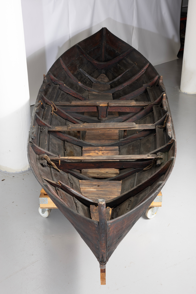 Treroring fra Sunnmøre, med div. løsøre ( 3 par årer, mast og rundholt, tiljer, tofter). Selvgrodde keiper. Råte babord baug.