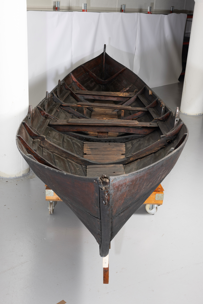 Treroring fra Sunnmøre, med div. løsøre ( 3 par årer, mast og rundholt, tiljer, tofter). Selvgrodde keiper. Råte babord baug.