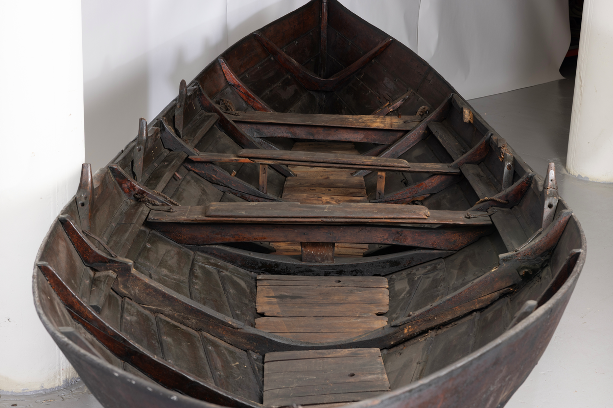 Treroring fra Sunnmøre, med div. løsøre ( 3 par årer, mast og rundholt, tiljer, tofter). Selvgrodde keiper. Råte babord baug.